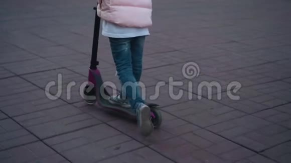 在街上骑滑板车的女孩滑板车腿的特写视频的预览图