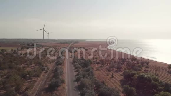 靠近大海的田野上的风力发电站视频的预览图