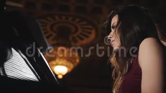 一个女人在音乐厅弹钢琴背景中巨大的吊灯视频的预览图