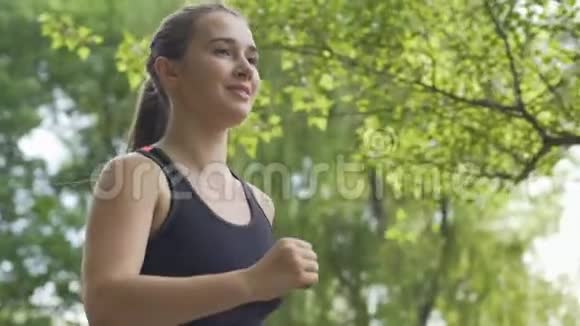 微笑的女人在阳光下奔跑早晨在新鲜空气中慢跑美丽的运动视频的预览图