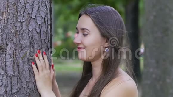 室外微笑美丽大树旁深褐色头发的女性生活快乐幸福视频的预览图