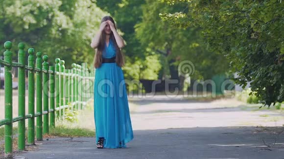 快乐的微笑女人穿着蓝色衣服站在户外摆姿势跳舞慢动作视频的预览图
