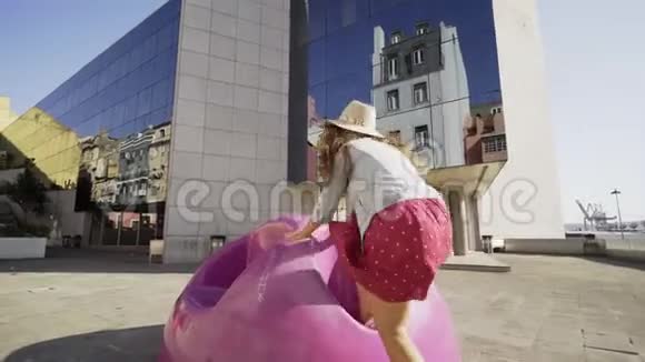 年轻女子骑着现代的椅子在街上视频的预览图