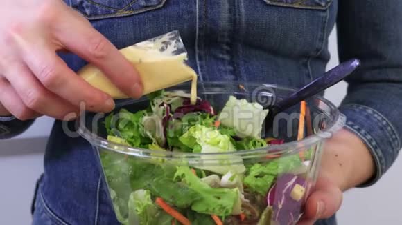 女人在蔬菜沙拉中倒入酱汁视频的预览图