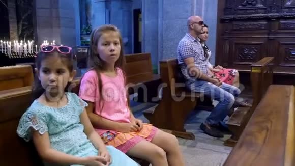奥罗帕比利亚意大利2018年7月7日人们儿童和成年人坐在天主教老教堂的长凳上视频的预览图