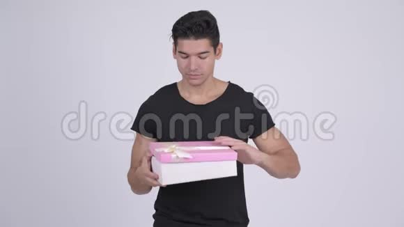 年轻快乐的多民族男人打开礼物盒看上去很惊讶视频的预览图