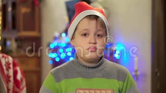 穿着毛衣的少年拿出礼物并微笑在圣诞灯的背景下视频的预览图