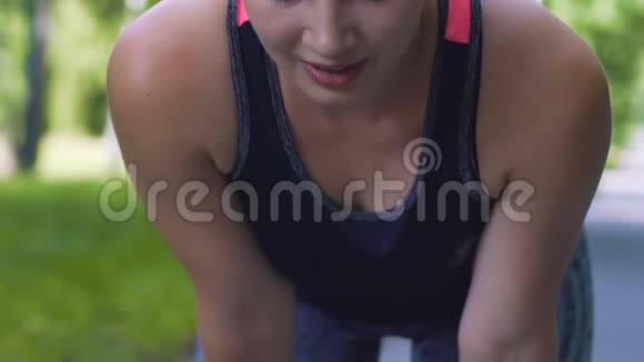 疲惫的女人弯腰长跑后休息女跑步者在训练中停下来视频的预览图