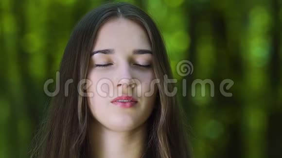 女人闭着眼睛在森林里沉思相机平底锅广告文本的地方慢视频的预览图
