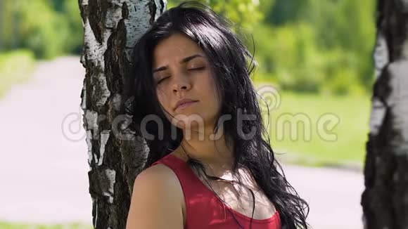 深黑的头发的雌鸟站在公园的桦树附近感觉与自然的合一视频的预览图