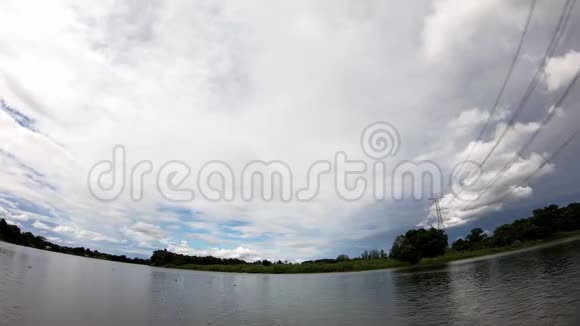 高压电线杆斜靠在河上白天天空中乌云密布视频的预览图