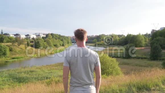 年轻人的后景环顾美丽的自然景观视频的预览图