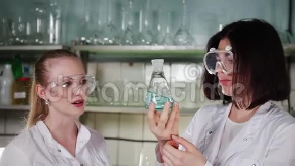 一个女人拿着瓶子和化学物质混合视频的预览图