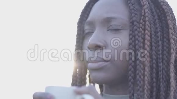 特写自信的非裔美国人年轻的黑人微笑的女人在街上喝着热咖啡慢慢视频的预览图