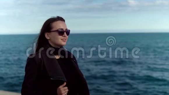 戴墨镜的女人在后台慢动作着大海视频的预览图