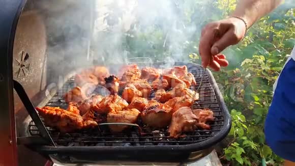 在烤架上用叉子把肉关起来以免烧坏烧烤和野餐海视频的预览图