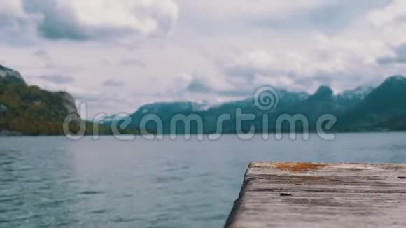 木墩的背景是一个山湖和雪阿尔卑斯山奥地利沃尔夫冈湖视频的预览图