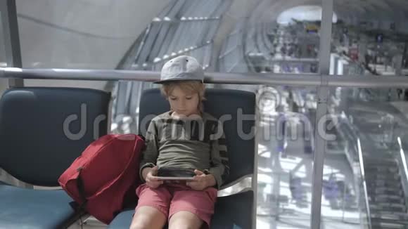 可爱的孩子在机场玩游戏用智能手机看电影视频的预览图