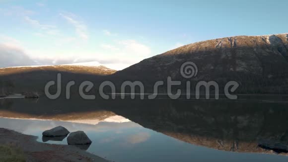 一个穿着运动服的男人看着湖中山峰的美丽倒影全景视频的预览图