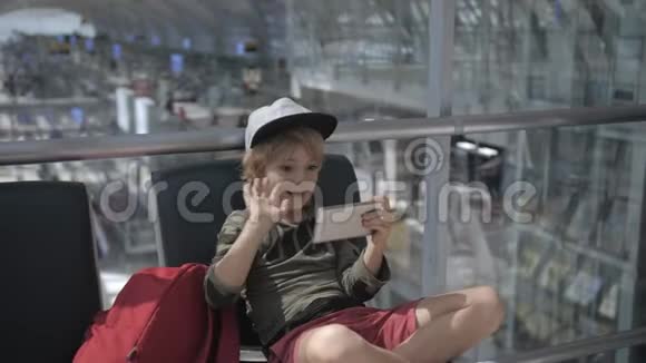 出发前在机场智能手机上可爱的儿童视频聊天视频的预览图