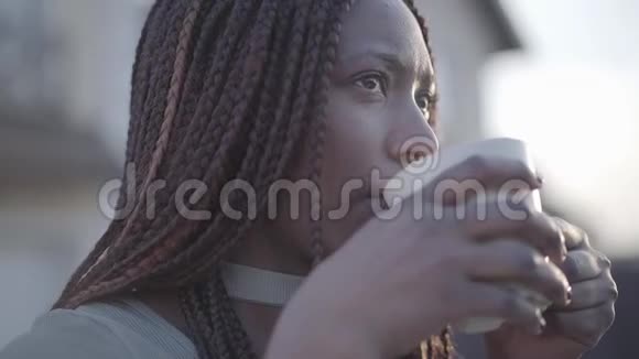 特写自信的非裔美国人年轻的黑人微笑的女人在街上喝着热咖啡慢慢视频的预览图