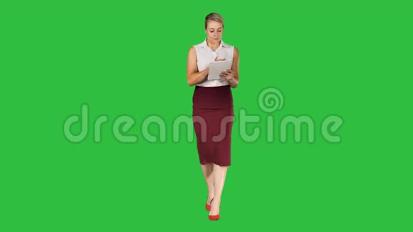 年轻的职业女性使用平板电脑走到相机上的绿色屏幕Chroma键视频的预览图