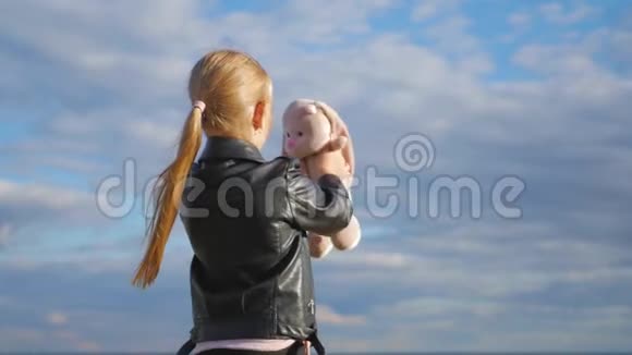 小女孩拿着大毛绒兔子玩具纺织手工玩具兔子在女孩手上孩子梦想的概念视频的预览图