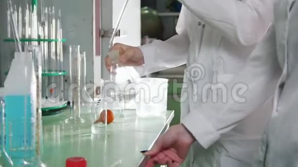 化学实验室两个年轻的女人在做实验注入红色的液体然后消失视频的预览图