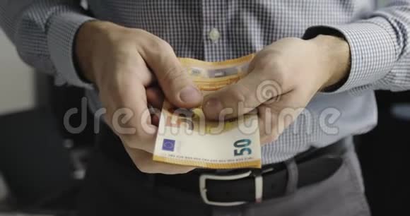 男性手的特写数着一包50欧元的钞票视频的预览图