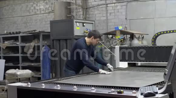 工程师在数控激光机床上调整切割金属板的铁片视频的预览图