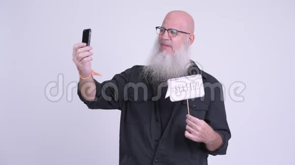 快乐的成熟的秃头的男人用纸签自拍视频的预览图