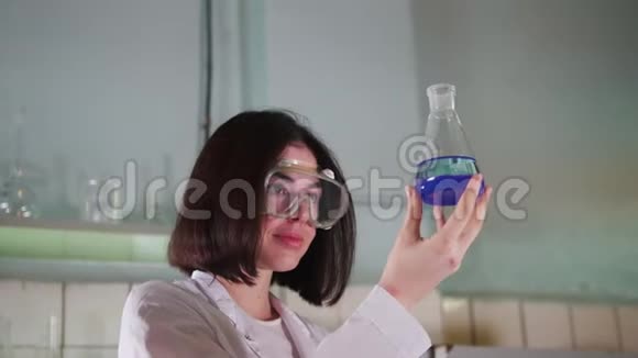 一个女人在医学实验室里看着蓝色的水视频的预览图