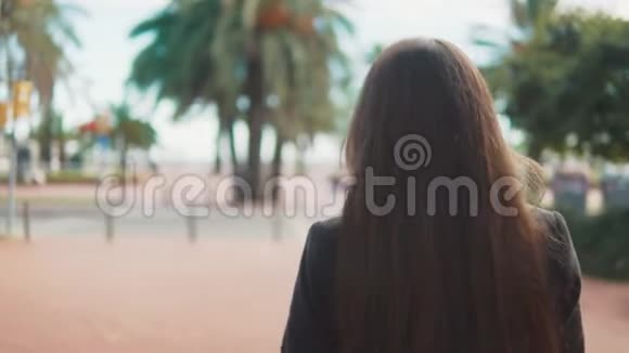迷人的年轻旅游妇女在棕榈树附近游荡视频的预览图