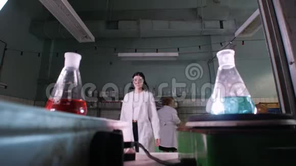一位妇女在医学实验室里混合加热的液体视频的预览图