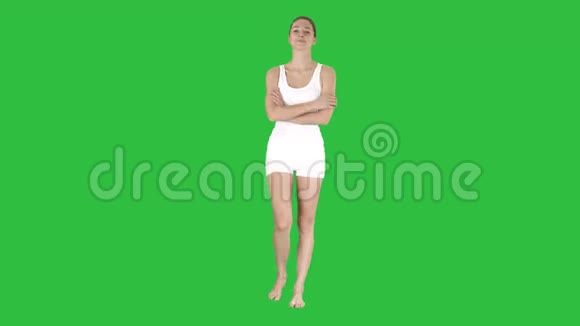 微笑的运动女性走着双臂交叉看着绿色屏幕上的相机Chroma键视频的预览图
