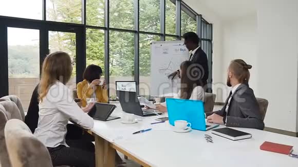 非裔美国人在挂图上绘制图表并坚持为公司的商业同事展示视频的预览图