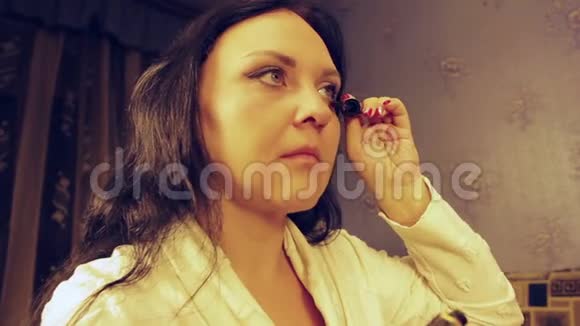 一个穿着白大褂的年轻女子用睫毛膏抽着睫毛视频的预览图