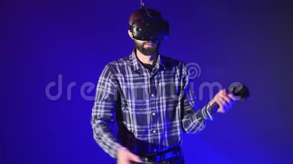 人玩3D虚拟现实游戏在VR游戏中用控制器挥舞剑戴着VR耳机的男子视频的预览图