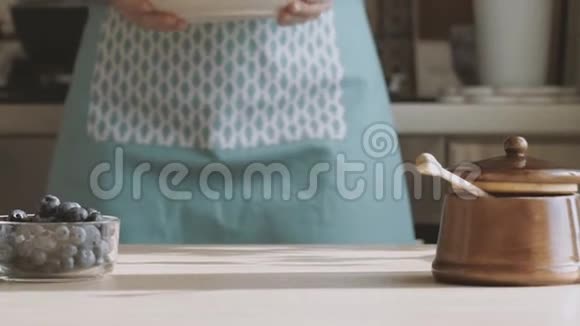 女厨师将芝士蛋糕西尼基传统俄式薄饼和蓝莓干酪放在桌上视频的预览图