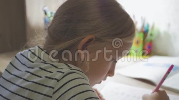 可爱的女孩做作业女学生在家里的桌子上学习孩子们教育视频的预览图