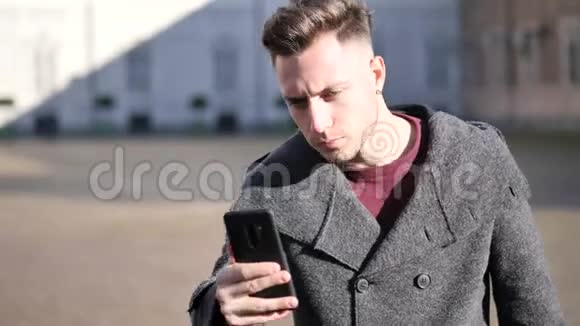 穿着冬衣的年轻人在智能手机上自拍视频的预览图