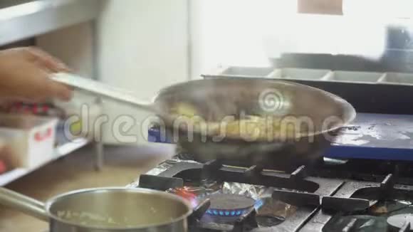 厨师把洋葱和腌制的蘑菇混合在煎锅里手的特写动作视频的预览图