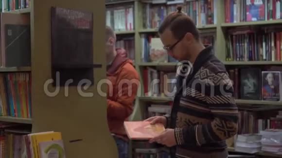 年轻人在书店里挑选一本书视频的预览图