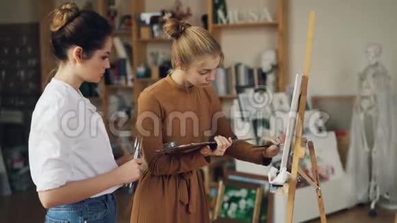 勤奋的学生是在专业艺术家的指导下在现代工作室合作创作的绘画作品女人是视频的预览图
