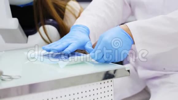 牙医在蓝色乳胶手套打开包装与牙科无菌工具特写视频的预览图