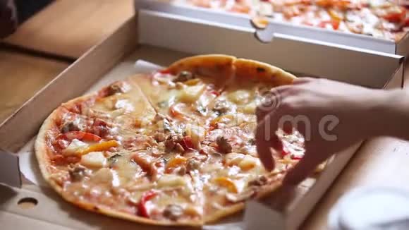 多种族人士的双手从盒子里拿意大利披萨片视频的预览图