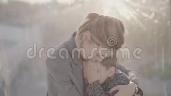 年轻的母亲在户外拥抱她的儿子视频的预览图