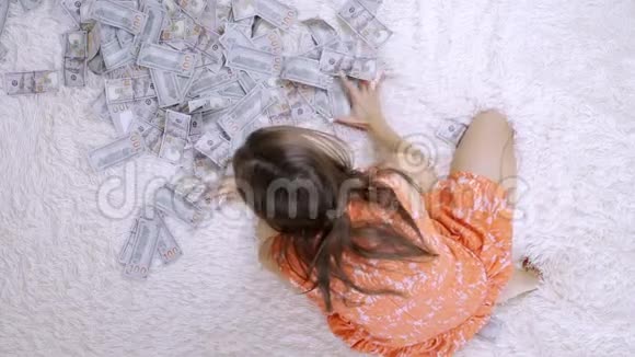 女人在床上翻来覆去的钞票很多钱慢动作俯视视频的预览图