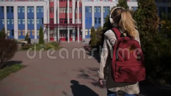 可爱的女学生走向学校大楼视频的预览图