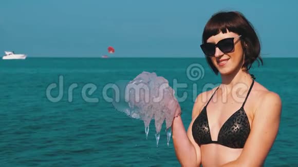女人在黑海的背景下抱着一只大海蜇根瘤菌视频的预览图